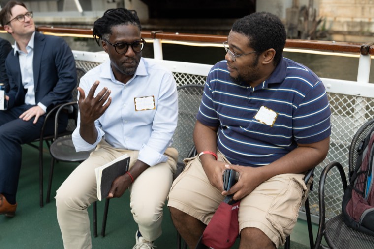 Two guests seated along the rail deep in conversation